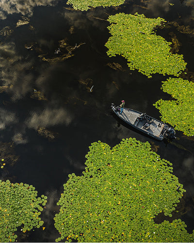 Boat on a body of water with green algae