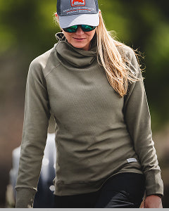 Person wearing a green long-sleeve shirt and cap with a blurred background