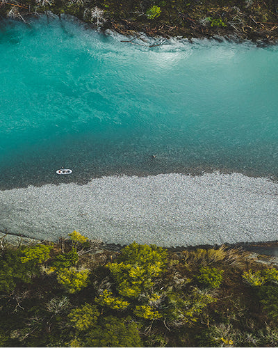 Aerial view of a turquoise lake surrounded by greenery