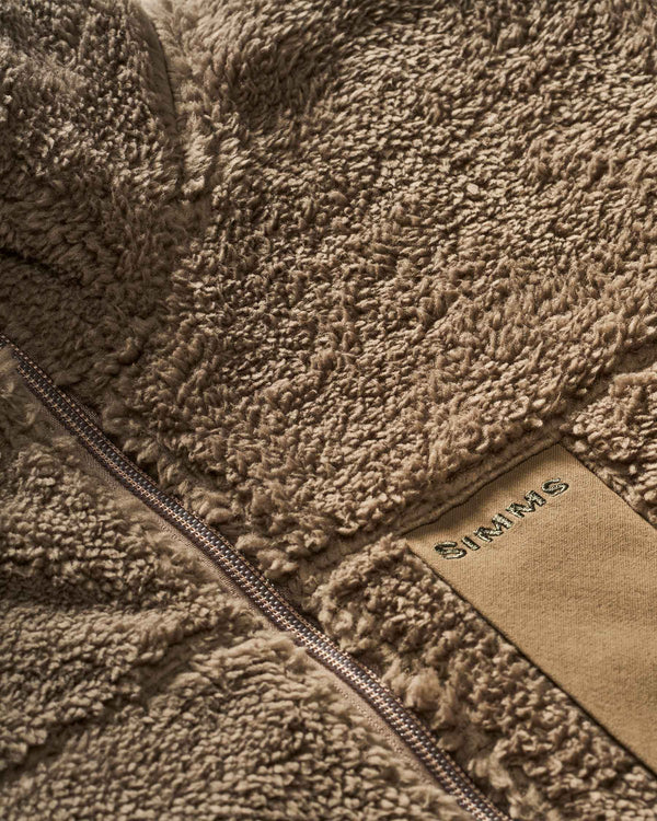 Close-up of a brown fleece jacket with a visible brand logo.