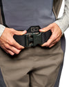 Women's Waders G3 Pro Guide Stockingfoot Close-up of a person wearing a black G-3 waist belt with a dark green quick-release buckle, shown being adjusted at the waist.