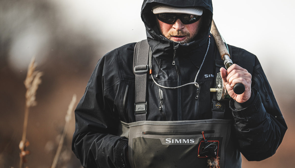 Technical leadership is in the Simms fishing DNA. Image of fly anglers holding a fly rod headed to the river.